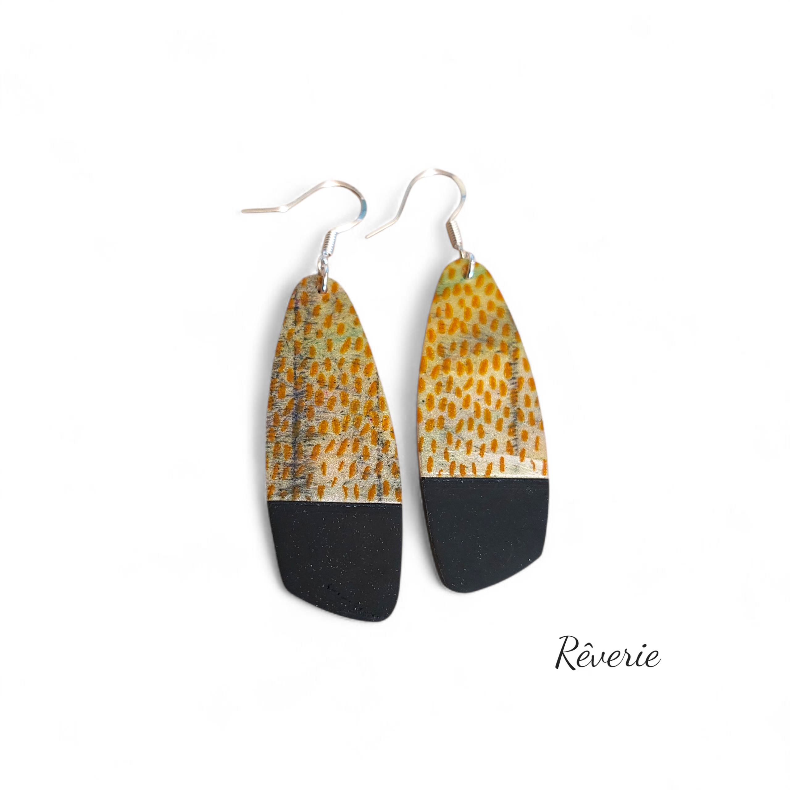 Warm tones and modern lines. These handcrafted polymer clay earrings feature an abstract saffron-yellow texture paired with a bold matte black base.