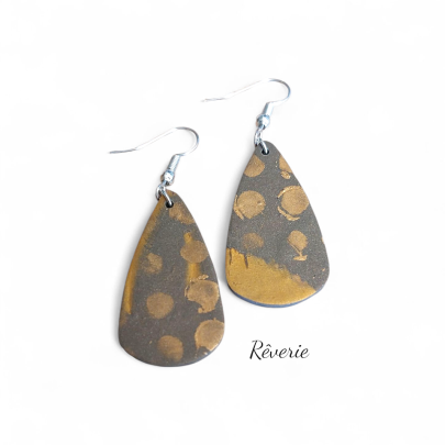 teardrop-shaped polymer clay earrings feature hand-applied gold dots over a deep charcoal base